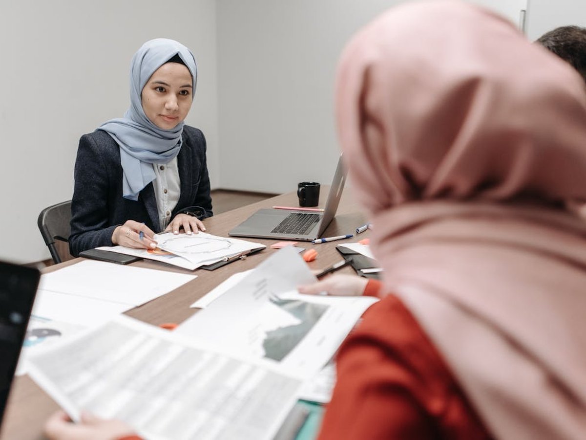 A Hiijra consultant reviewing a portfolio with a client